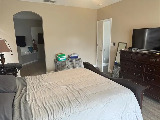a bedroom with a bed and a flat screen tv