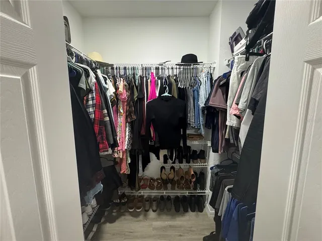 a view of walk in closet with clothes