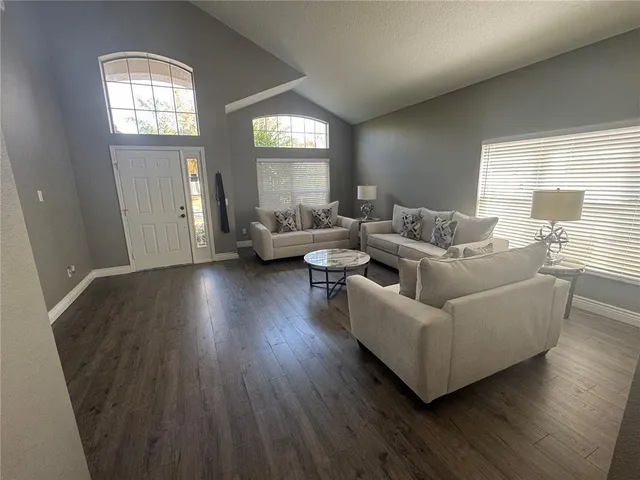a living room with couches and a large mirror with wooden floor
