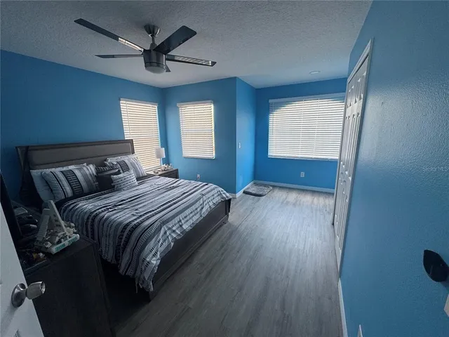 a bedroom with a bed and a flat tv screen on dresser