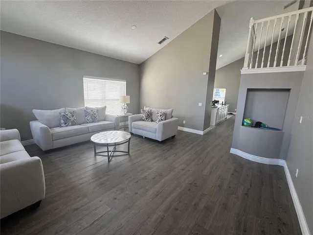 a living room with furniture and a wooden floor