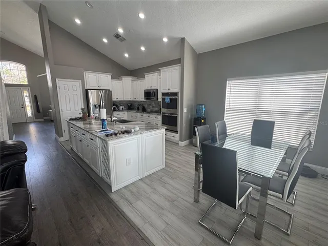 a large white kitchen with a table and chairs