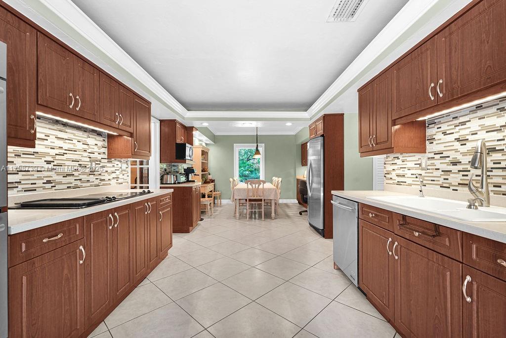 6551 Southwest 126th Street Pinecrest, FL 33156 - Photo 17 of 39 a kitchen with counter top space and wooden cabinets