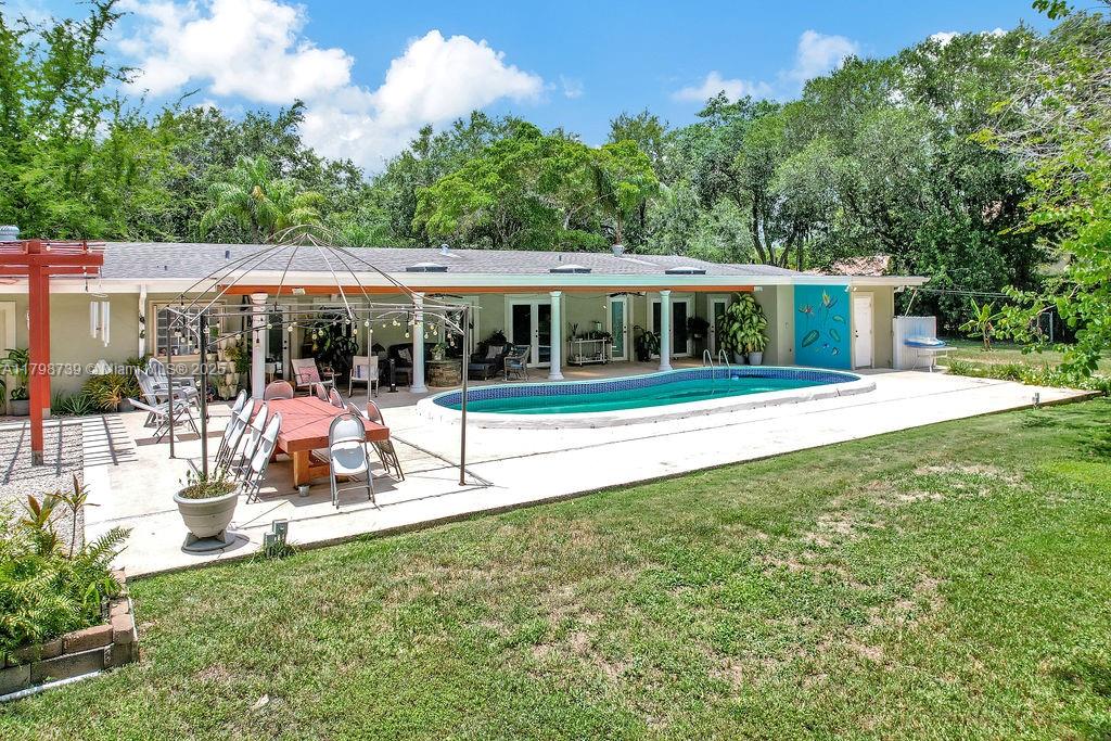 6551 Southwest 126th Street Pinecrest, FL 33156 - Photo 39 of 39 a front view of a house with a yard table and chairs