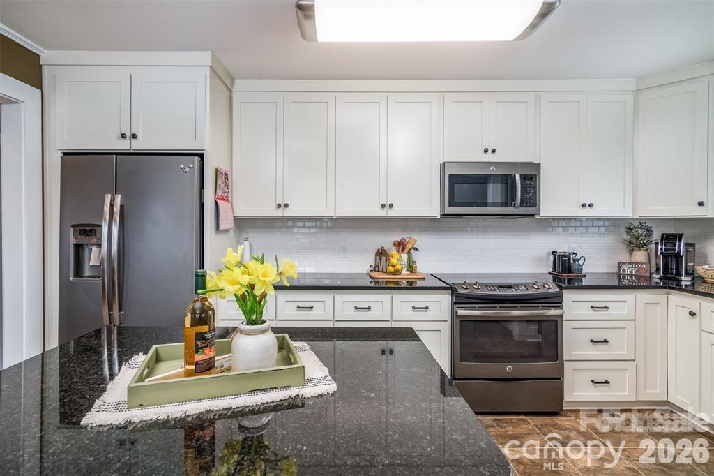 1004 Valley Street Kannapolis, NC 28081 - Photo 5 of 18 a kitchen with stainless steel appliances a stove a refrigerator a stove a white table and chairs