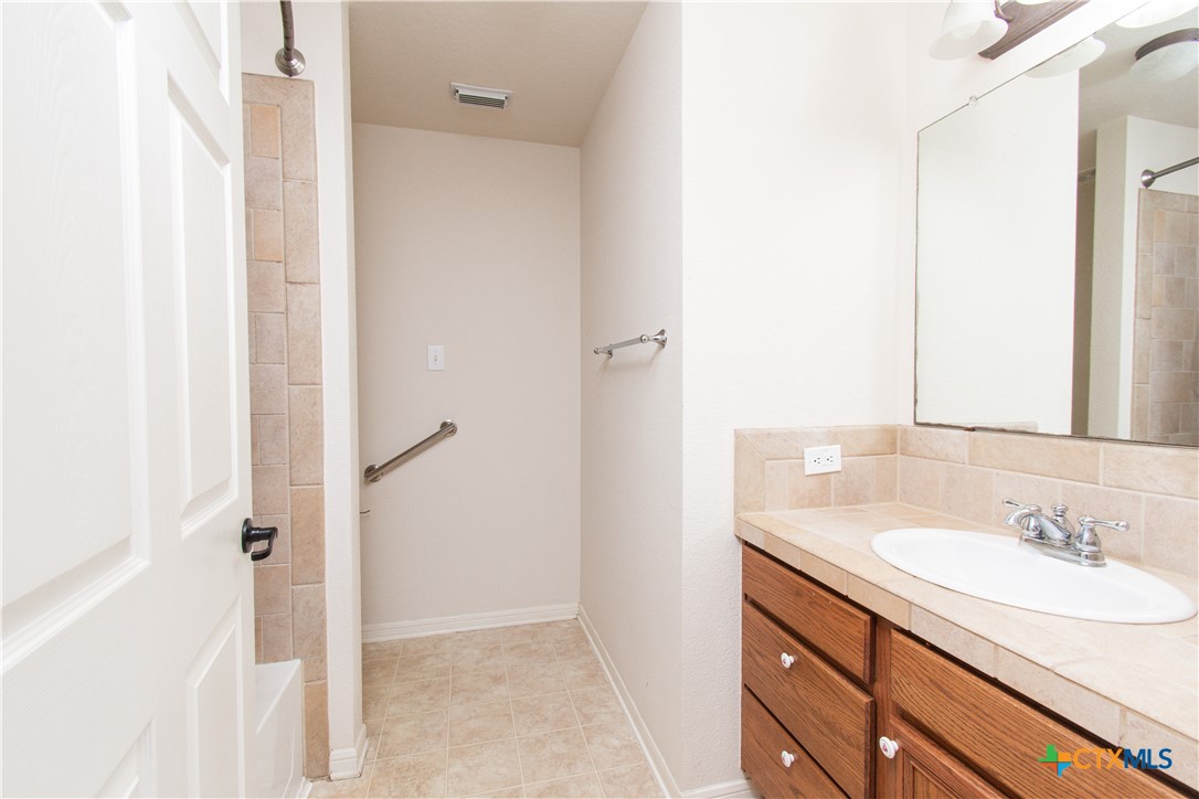 309 Ellis Street San Marcos, TX 78666 - Photo 11 of 18 a bathroom with a sink and a mirror