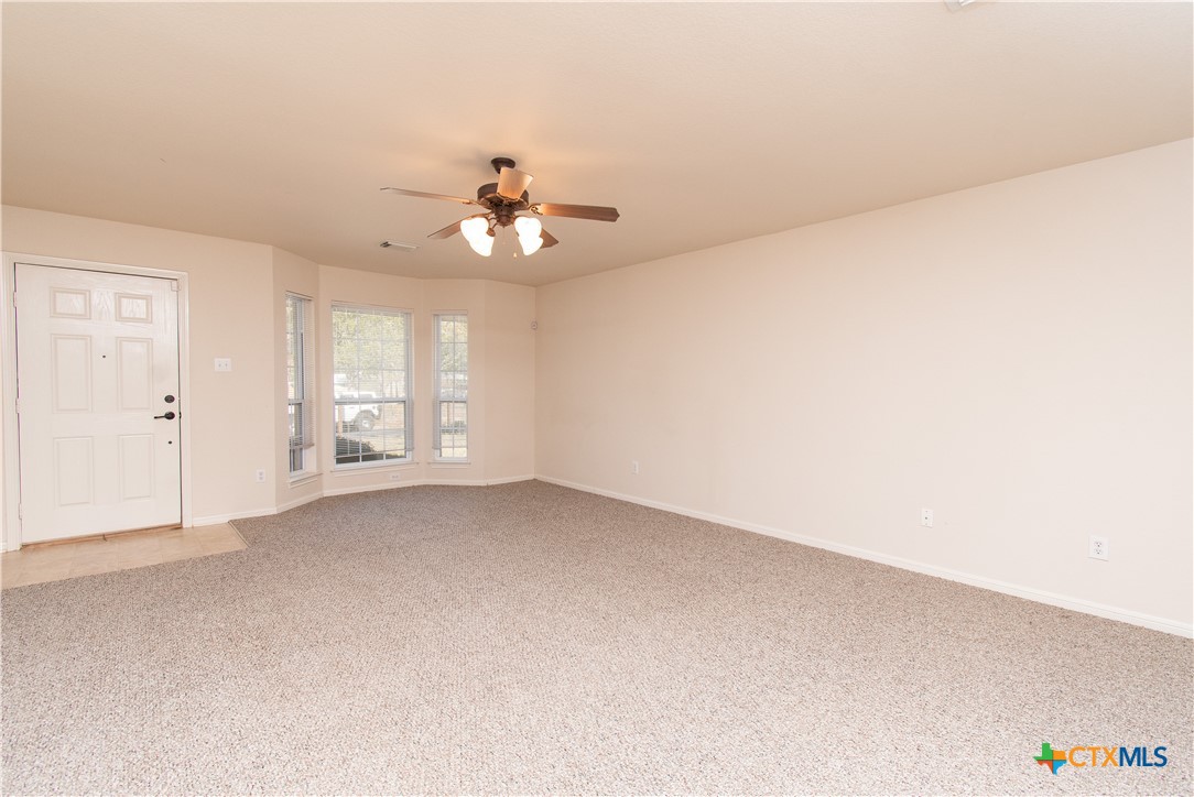 309 Ellis Street San Marcos, TX 78666 - Photo 3 of 18 an empty room with windows and chandelier fan