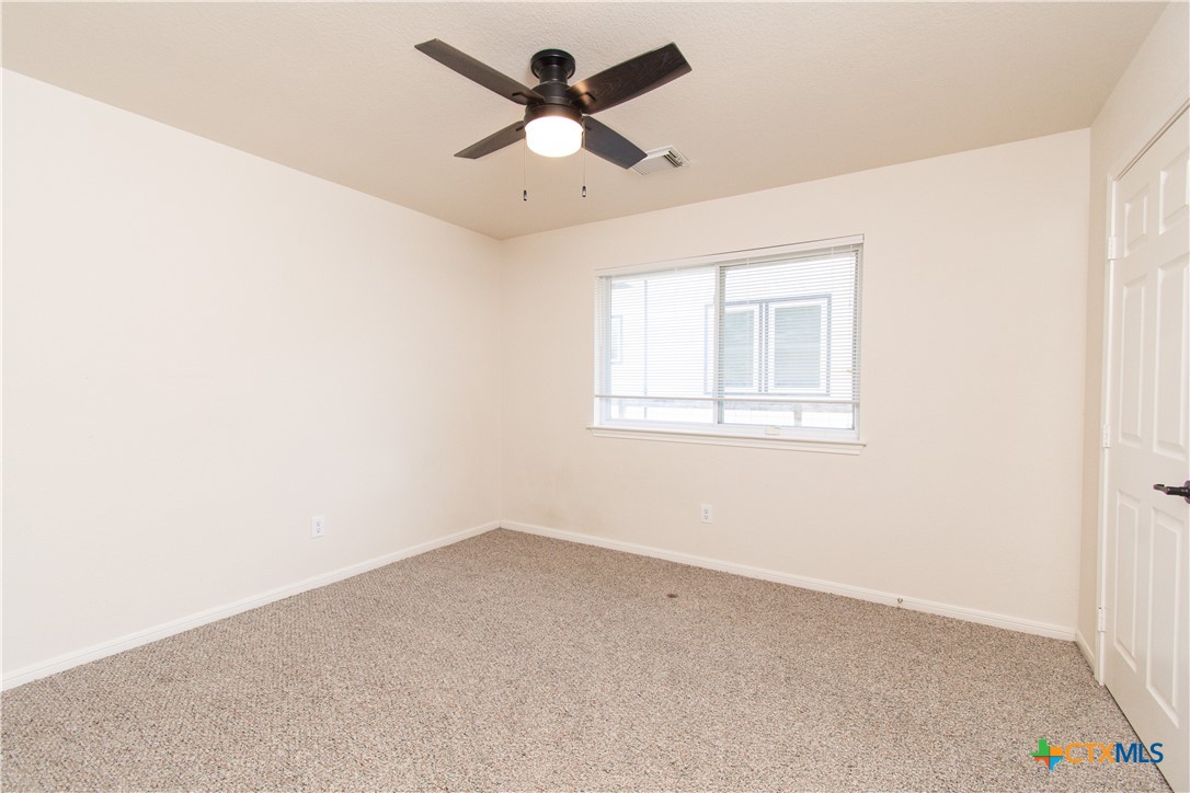 309 Ellis Street San Marcos, TX 78666 - Photo 8 of 18 an empty room with a window and a ceiling fan