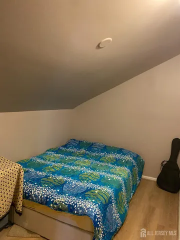 a bedroom with a bed and a lamp on the dresser