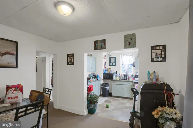 a kitchen with furniture a refrigerator a stove a sink a dining table and chairs with wooden floor