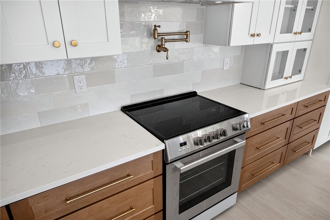 414 Blume Road Anderson, SC 29625 - Photo 26 of 50 An elegant pot filler accents the tiled backsplash above a modern stainless steel range.