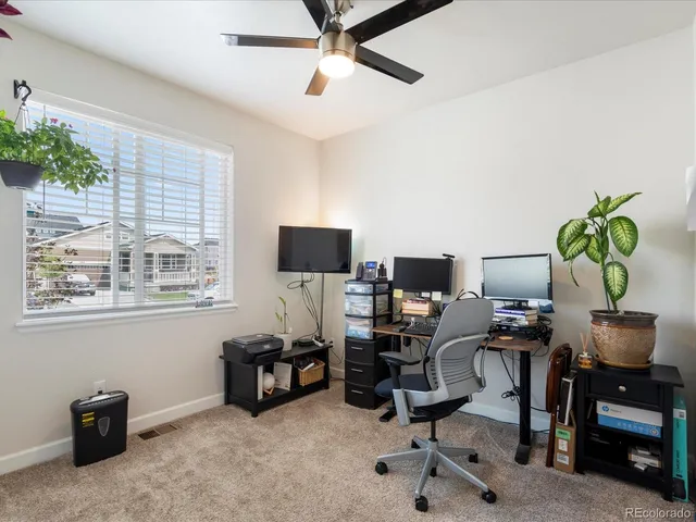 a view of a workspace with furniture and a window