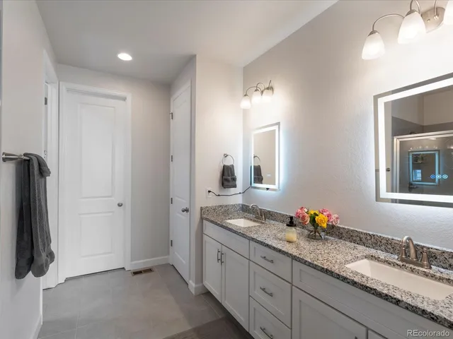 a bathroom with a granite countertop sink and a mirror