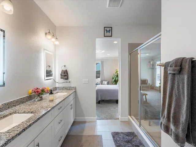 a bathroom with a granite countertop sink mirror and shower