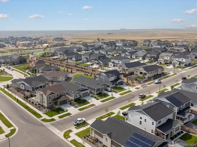an aerial view of a city with lots of residential buildings and ocean view in back
