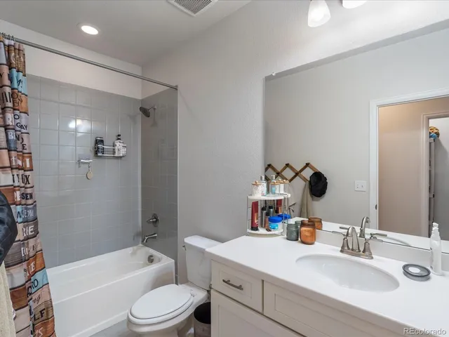 a bathroom with a granite countertop sink mirror toilet and bathtub