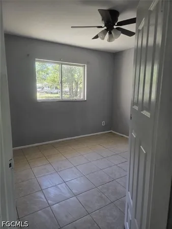 a view of an empty room and a ceiling fan window