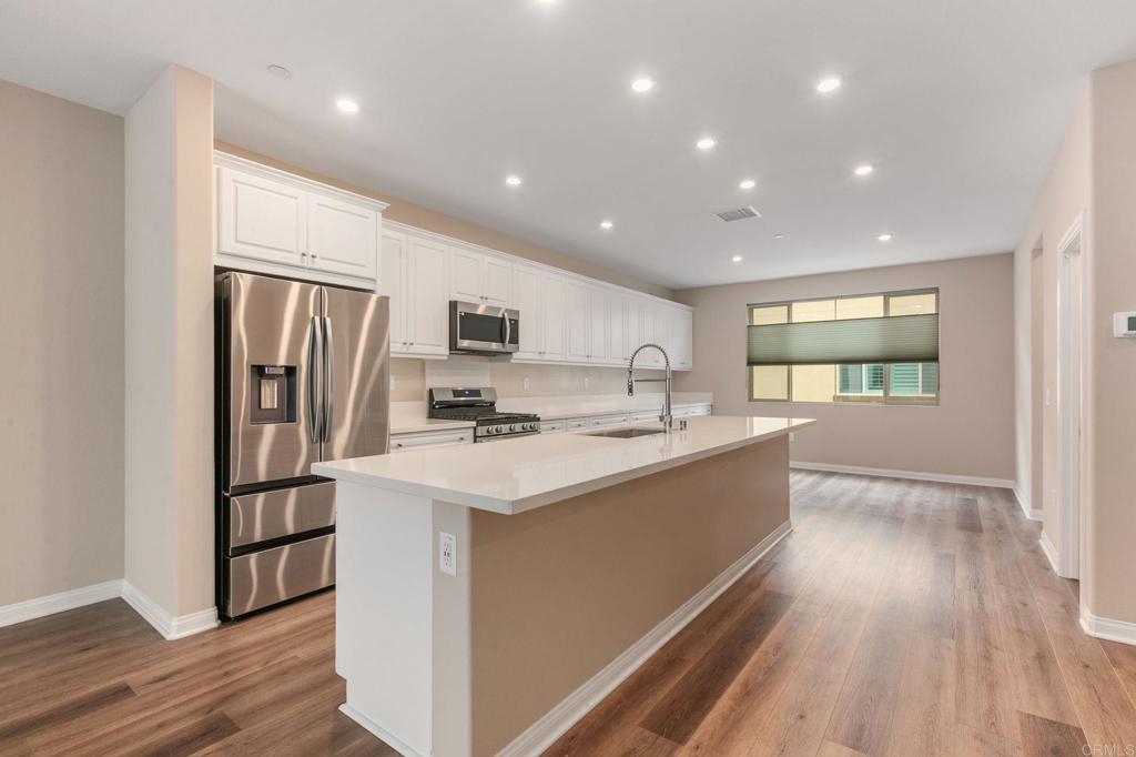 1771 Laurelwood Way Oceanside, CA 92056 - Photo 12 of 46 a large kitchen with stainless steel appliances granite countertop a refrigerator and a stove top oven