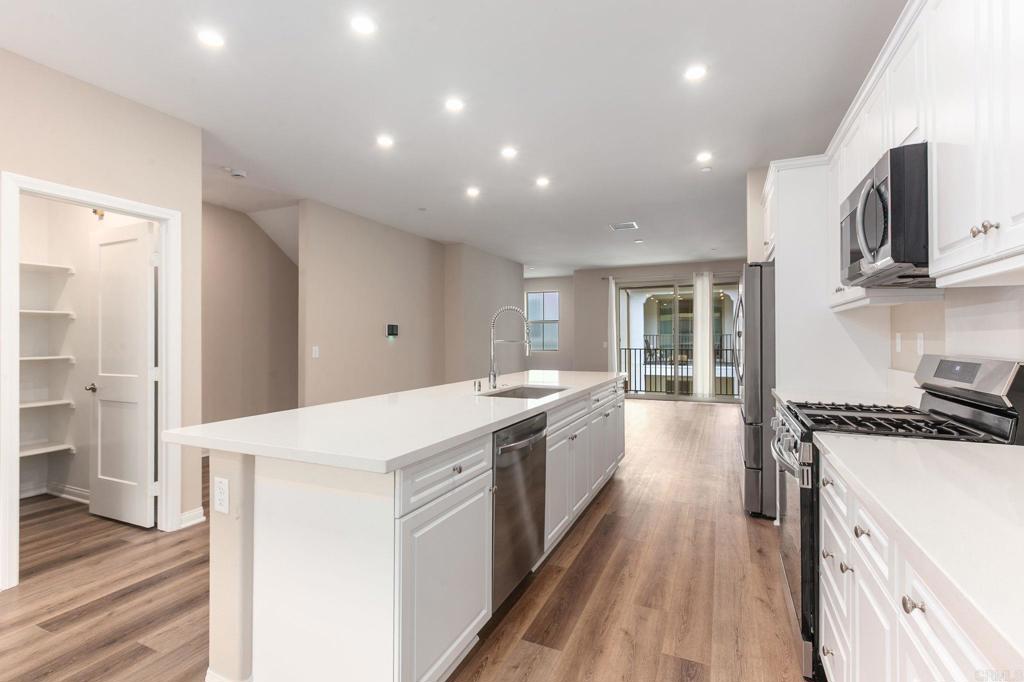 1771 Laurelwood Way Oceanside, CA 92056 - Photo 14 of 46 a large kitchen with stainless steel appliances granite countertop a lot of counter space and wooden floors