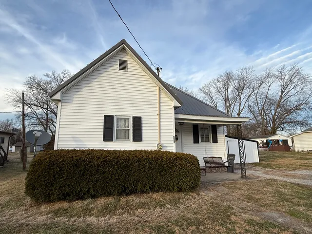 a house that has a large tree in front of it