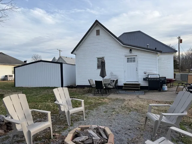 a view of a backyard with chairs and a patio