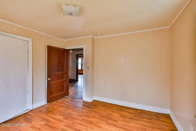 a view of empty room with wooden floor