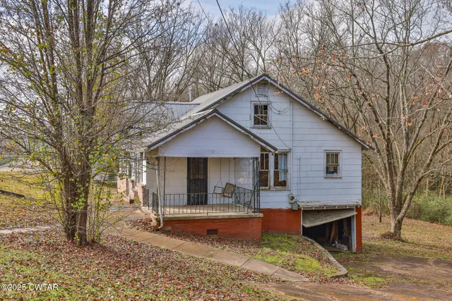 a front view of house with yard and trees in the background