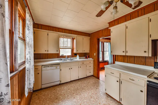 a kitchen with white cabinets and sink
