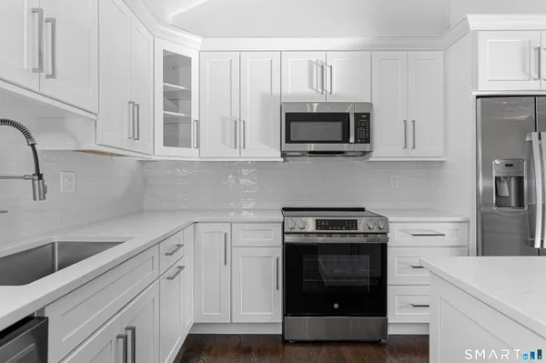 a kitchen with cabinets stainless steel appliances and a sink