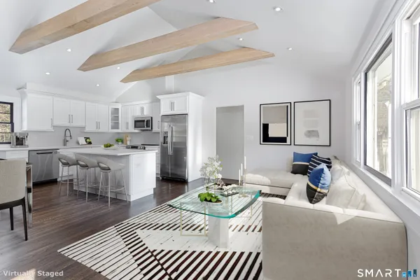 a living room with kitchen island furniture and a view of kitchen