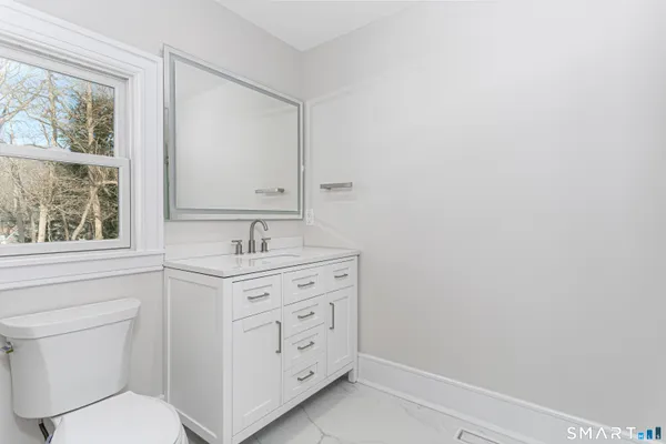 a bathroom with a sink a toilet and a window