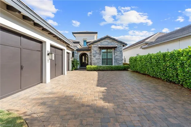 a view of a white house with a yard and plants