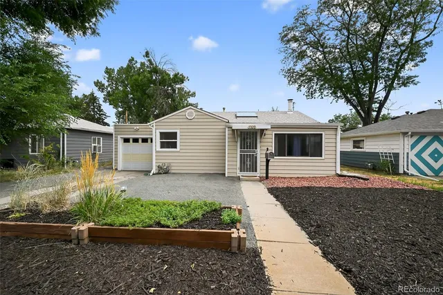 a front view of a house with a yard and potted plants