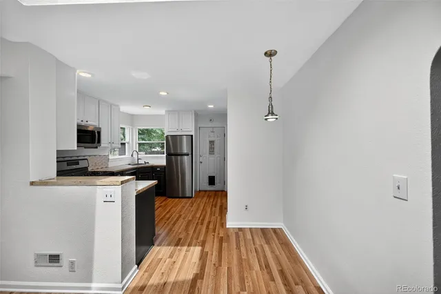 a kitchen with granite countertop a refrigerator stove top oven and sink