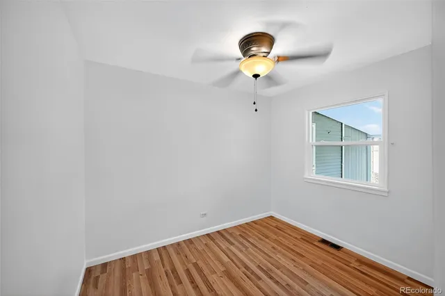 a view of room with a ceiling fan and wooden floor