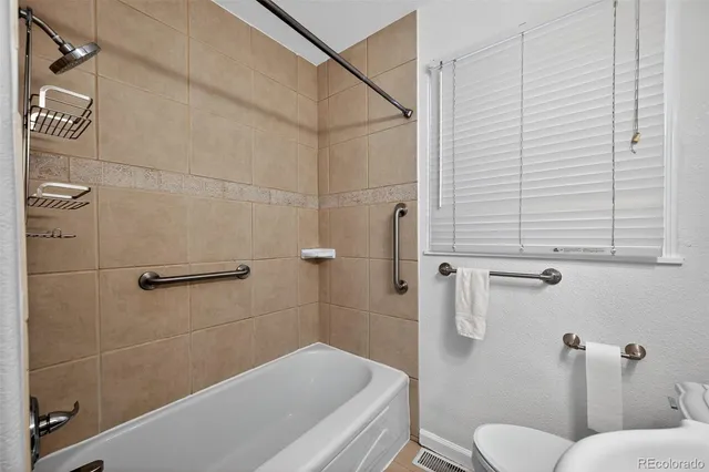 a bathroom with a toilet and a shower