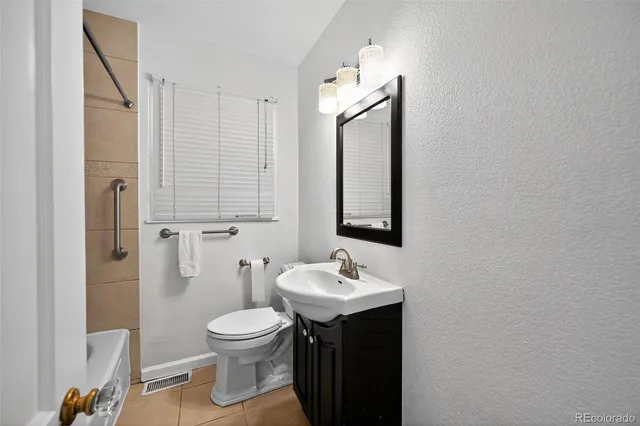 a bathroom with a toilet sink and mirror