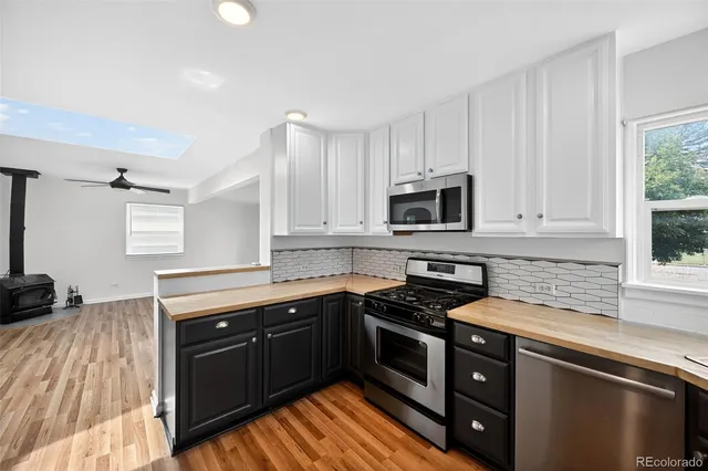 a kitchen with granite countertop a sink cabinets and stainless steel appliances