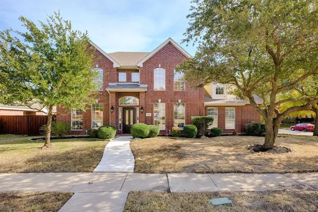 a front view of a house with a yard and trees