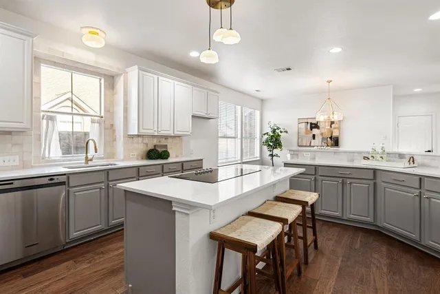 a kitchen with sink a microwave and cabinets