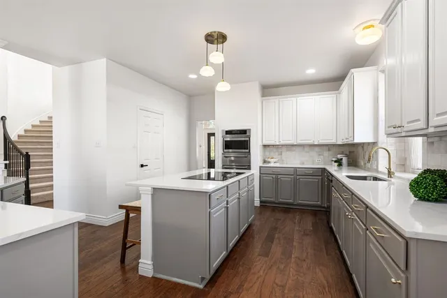 a kitchen with a sink stove cabinets and refrigerator