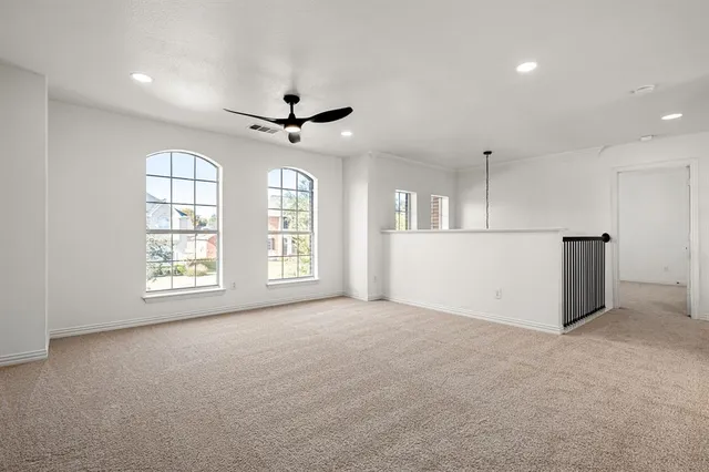 a view of an empty room with a window and a kitchen