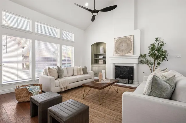 a living room with furniture a large window and a fireplace