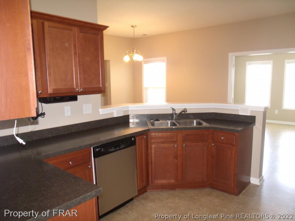 1448 Rough Rider Lane Parkton, NC 28371 - Photo 13 of 36 a kitchen with granite countertop a sink a stove and cabinets