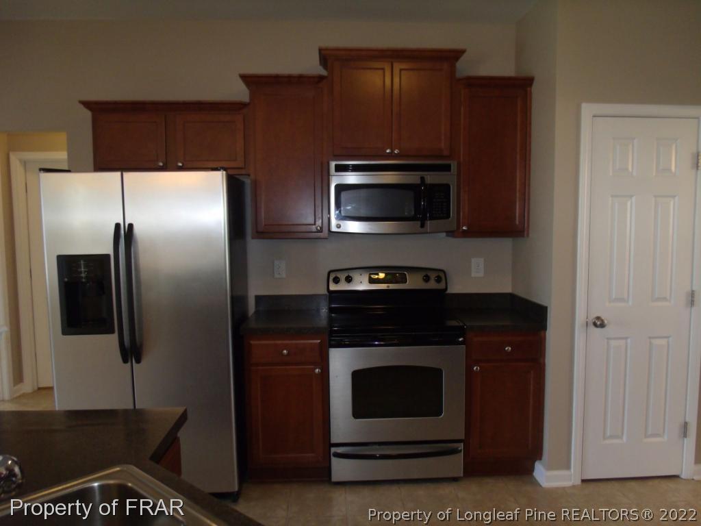 1448 Rough Rider Lane Parkton, NC 28371 - Photo 14 of 36 a kitchen with a refrigerator stove and microwave
