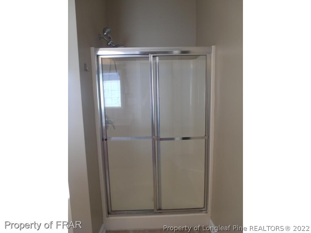 1448 Rough Rider Lane Parkton, NC 28371 - Photo 18 of 36 a bathroom with a glass shower door