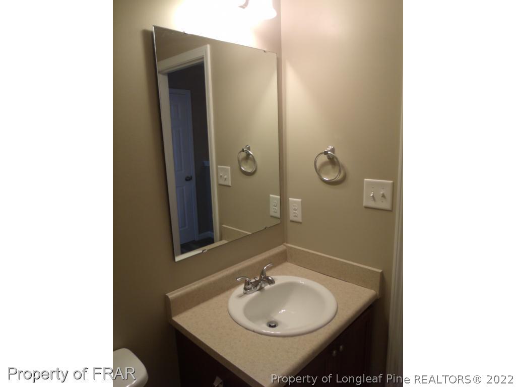 1448 Rough Rider Lane Parkton, NC 28371 - Photo 22 of 36 a bathroom with a sink and a mirror