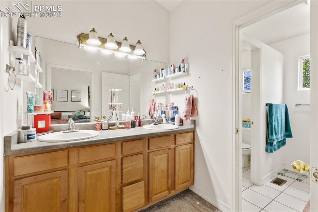 4573 Prestige Point Colorado Springs, CO 80906 - Photo 19 of 31 Full bathroom featuring light tile patterned flooring and double vanity