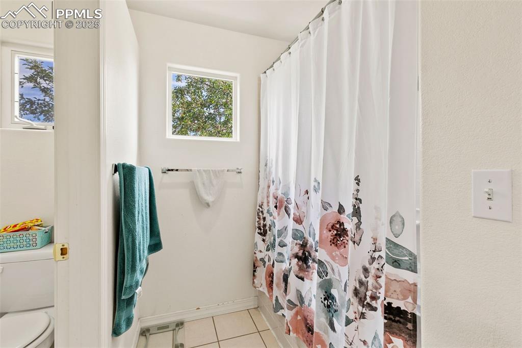 4573 Prestige Point Colorado Springs, CO 80906 - Photo 20 of 31 Full bathroom featuring light tile patterned floors and curtained shower