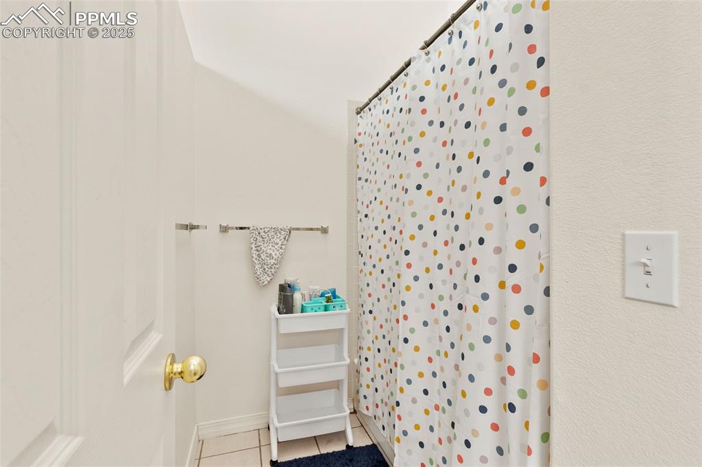 4573 Prestige Point Colorado Springs, CO 80906 - Photo 27 of 31 Full bathroom with light tile patterned floors and a stall shower